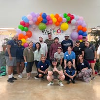 WeHOP team photo under a balloon arch
